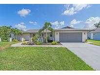 Charming single-story home featuring a gray roof, a two-car garage, and lush landscaping at 4396 Pasadena Cir, Sarasota, FL 34233