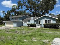 Two-story home featuring a light blue exterior, white trim, classic shutters, and a cozy front porch area at 5124 17Th Street E Ct, Bradenton, FL 34203