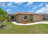 Charming single-story home with a well-manicured lawn and colorful landscaping at 529 Sunset N Rd, Rotonda West, FL 33947