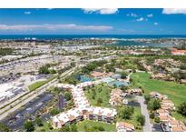 Beautiful aerial view of the community with lush landscaping, a pool, and ocean views at 618 Bird Bay S Dr # 113, Venice, FL 34285