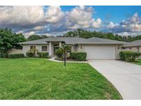 Charming single-story home featuring a well-manicured lawn and attached two-car garage at 813 Oak Pond Dr, Osprey, FL 34229