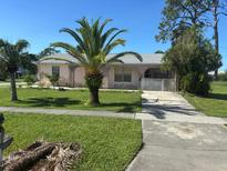 Modest single-story home with a palm tree in the front yard and a concrete driveway at 8409 Trionfo Ave, North Port, FL 34287