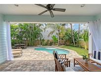 Inviting outdoor space featuring a kidney-shaped pool, tropical landscaping, and a covered patio with comfortable seating at 1738 Siesta Dr, Sarasota, FL 34239