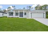Beautiful new construction home with a well-manicured lawn and clean, modern architecture at 2523 Hagerick Ln, North Port, FL 34288