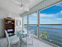 Bright dining area with water view, glass table, coastal decor, and plenty of natural light at 4420 Exeter Dr # 303, Longboat Key, FL 34228