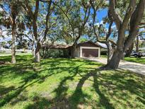 Charming single-story home featuring a two-car garage and surrounded by mature trees and lush greenery at 5629 Boulder Blvd, Sarasota, FL 34233