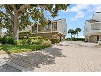 Beautiful two-story house with mature landscaping and a brick driveway at 65 Tidy Island Blvd, Bradenton, FL 34210