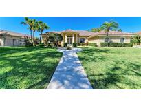 Inviting single-story home featuring lush landscaping, a tiled roof, and a walkway to the front entrance at 8315 Eagle Xing, Sarasota, FL 34241