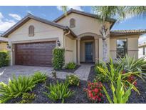 Inviting single-Gathering home featuring a well-manicured lawn and a charming exterior with a two-car garage at 11221 Sandhill Preserve Dr, Sarasota, FL 34238
