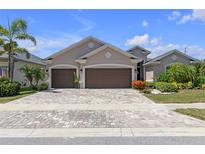 Charming single-story home featuring a three-car garage, mature landscaping, and a brick-paved driveway at 12398 Keyridge Loop, Largo, FL 33778
