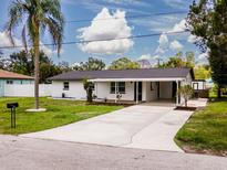 Charming single-story home with a lush green lawn, a newly paved driveway and a welcoming covered entrance at 211 22Nd Street Ne Ct, Bradenton, FL 34208