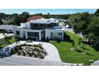 Stunning contemporary home featuring a modern design, lush landscaping, and a circular driveway at 2110 Michele Dr, Sarasota, FL 34231