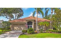 Charming single-story home features a tile roof, manicured landscaping, and a two-car garage at 2518 Dick Wilson Dr, Sarasota, FL 34240