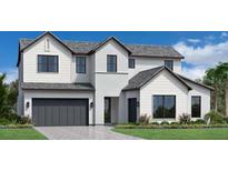 Beautiful two-story home with gray roof, attached two car garage, manicured lawn and lush landscaping at 2537 Waterfront Cir, Sarasota, FL 34240