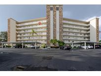 Condo building featuring balconies, covered parking, manicured landscaping, and a stone accent center at 3680 Ironwood Cir # 603L, Bradenton, FL 34209