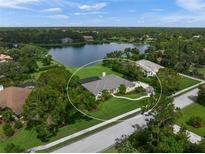 An aerial view of a single-Gathering home on a large lot with lake views and a screened-in pool at 5012 Cherry Laurel Way, Sarasota, FL 34241