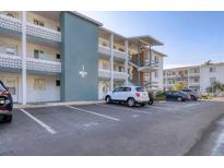 Low angle exterior of a condo building with parking spaces and second story apartments at 5891 Welcome Rd # I6, Bradenton, FL 34207