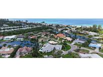 Stunning waterfront home with a private pool and dock, nestled in a lush tropical landscape near the beach at 670 Old Compass Rd, Longboat Key, FL 34228