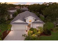 Inviting two-story home featuring a well-manicured lawn, a neutral stucco exterior, and a two-car garage at 1245 Millbrook Cir, Bradenton, FL 34212