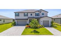 Beautiful two-story home boasts a two-car garage, lush landscaping, and a neatly paved driveway at 15336 Serene Shores Loop, Bradenton, FL 34211