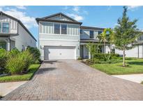 Charming two-story home with well-manicured landscaping and a brick-paved driveway at 16418 Slate Pl, Lakewood Ranch, FL 34211