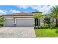 Well-maintained single-Gathering home with three-car garage, stone accents, and lush landscaping at 17850 Polo Trl, Bradenton, FL 34211