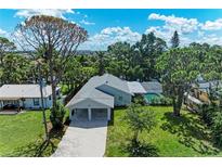 Inviting single-story home with a carport, lush greenery, and sparkling pool view at 2400 Lake Shore Dr, Nokomis, FL 34275