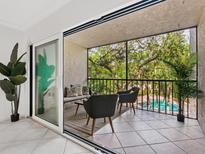 Relaxing balcony with comfortable seating overlooking lush greenery and a refreshing pool at 2748 Orchid Oaks Dr # 202, Sarasota, FL 34239