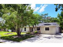 Charming single-story home featuring a well-manicured lawn, mature trees, and a cozy front exterior at 3236 Kingswood Dr, Sarasota, FL 34232