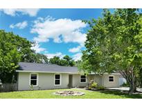 Charming single-story home with a well-manicured lawn, lush landscaping, and bright white window trim at 3236 Kingswood Dr, Sarasota, FL 34232