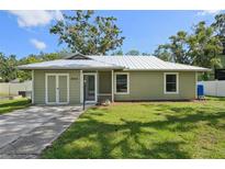 Charming single-story home with a well-maintained lawn and a classic, inviting facade with metal roof at 4023 Hina Dr, Sarasota, FL 34241