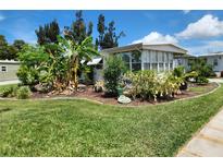 Well-maintained home featuring verdant landscaping and a cozy sunroom addition at 5402 Chateau Ln, Bradenton, FL 34207