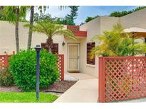 Charming courtyard entrance with lattice, palm trees, and a well-maintained walkway to the front door at 814 Spring Lakes Blvd # 14, Bradenton, FL 34210