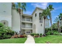 Elegant condo building with lush landscaping, balconies, and a charming walkway at 1000 San Lino Cir # 1034, Venice, FL 34292