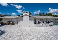 Charming single-story home with a white brick chimney, comfortable patio furniture, and a shell-covered yard at 1201 Big Oak Ln, Sarasota, FL 34242