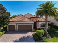 Beautiful single-Gathering home features a well-manicured lawn, large driveway, and a terracotta roof at 13026 Ramblewood Trl, Bradenton, FL 34211