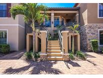 Inviting two-story home featuring charming front entryway stairs and well-maintained landscaping at 13714 Messina Loop # 202, Bradenton, FL 34211