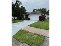 Charming one-story home with lush landscaping, a spacious driveway, and a two car garage at 1725 Briar Creek Ln, Sarasota, FL 34235