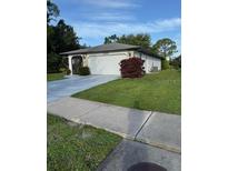 A single story home with a well-manicured lawn and attached garage with beautiful landscaping at 1725 Briar Creek Ln, Sarasota, FL 34235