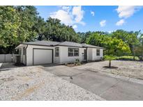 Charming single-story home featuring a well-maintained white exterior, a front yard, and a single car garage at 1857 Siesta Dr, Sarasota, FL 34239
