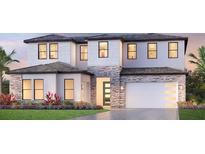 Two-story home with stone accents, a two-car garage, and lush landscaping at 2592 Waterfront Cir, Sarasota, FL 34240