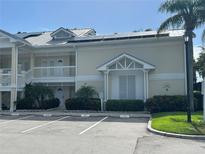 Condo exterior showcases a two-story facade, white railings, lush landscaping, and convenient parking at 3401 54Th W Dr # 201, Bradenton, FL 34210