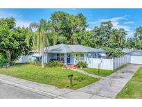Charming single-story home with a well-manicured lawn, palm tree, and a white picket fence at 401 N Jefferson Ave, Sarasota, FL 34237
