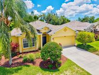 Charming yellow single-Gathering home with a well-manicured lawn and mature landscaping including Palm trees at 5004 Creekside Trl, Sarasota, FL 34243