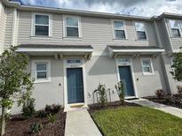 Inviting townhome exterior with landscaped yard and eye-catching, complementary-colored doors at 6253 Whetstone Ct, Palmetto, FL 34221