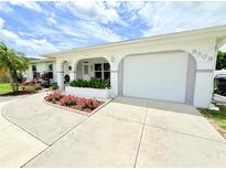 Charming home featuring an attached garage and beautiful flower beds that accentuate the property's curb appeal at 8509 La Boca Ave, North Port, FL 34287