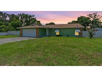 Charming home boasts a lush lawn, complemented by a stone-accented facade and a convenient two-car garage at 9543 Rockhill Rd, Thonotosassa, FL 33592