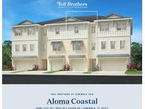 New construction three-story townhome showcasing a contemporary design with a two-car garage and white siding at 9992 Key Haven Rd, Seminole, FL 33777