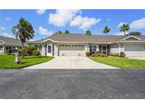 Charming single-story home with a large driveway, two-car garage and tropical landscaping at 2417 Fairway Oaks Dr # 22, Palmetto, FL 34221