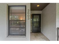 Inviting entryway featuring a black door, tile flooring, and a window, creating a warm welcome at 3003 Quail Holw # 10, Sarasota, FL 34235